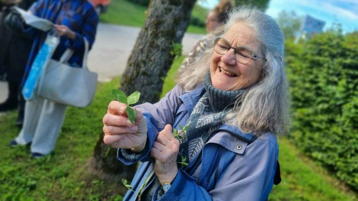 Vivian Craig tenant à la main du trèfle. Cette plante est réputée pour ses propriétés apaisantes pour les problèmes de peau chroniques, ou encore pour les problèmes respiratoires.