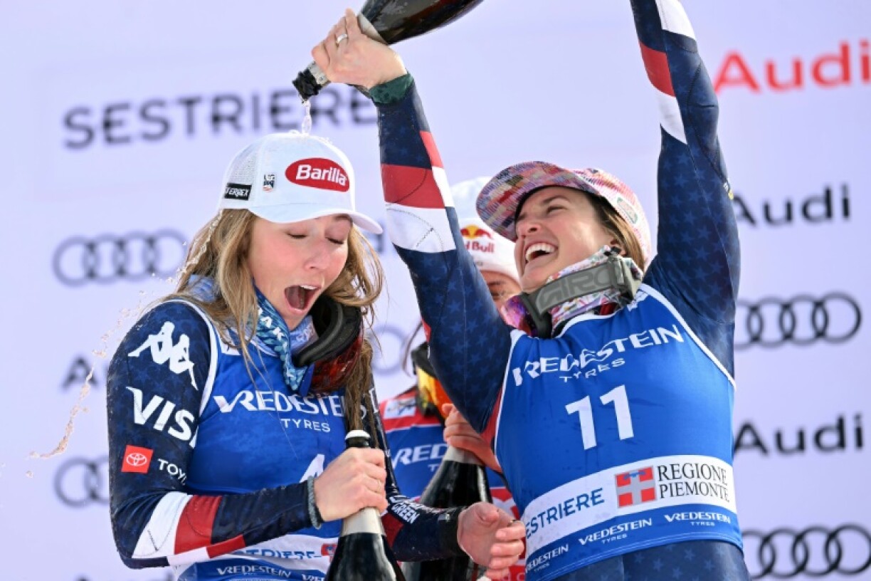 Mikaela Shiffrin (L) celebrates on the podium with fellow American Paula Moltzan after winning her 100th World Cup race in Sestriere