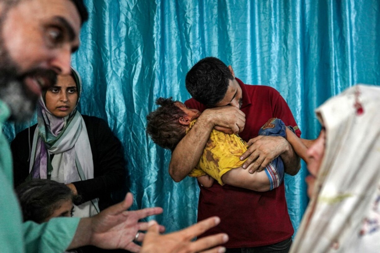 Un homme serre son enfant blessé dans ses bras à l'hôpital Deir el-Balah suite à un bombardement israélien dans le centre de la bande de Gaza, le 4 juin 2024
