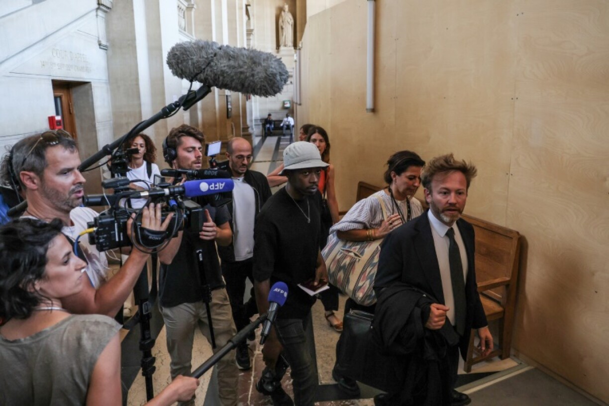 Le rappeur français Mohamed Sylla (C), alias MHD, arrive au palais de justice de Paris le 4 septembre 2023 avec ses avocats Antoine Vey (D) et Elise Arfi (2e D) pour le début de son procès aux assises