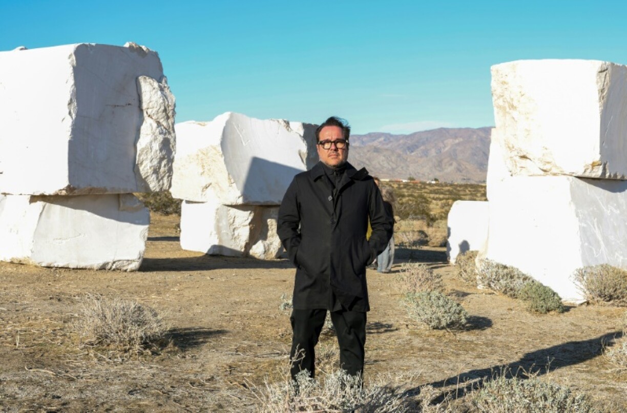 Mexican artist Jose Davila poses in front of his piece 'The Act of Being Together,' made of stacked 16-ton marble boulders ahead of the Desert X exhibit in California's Coachella Valley