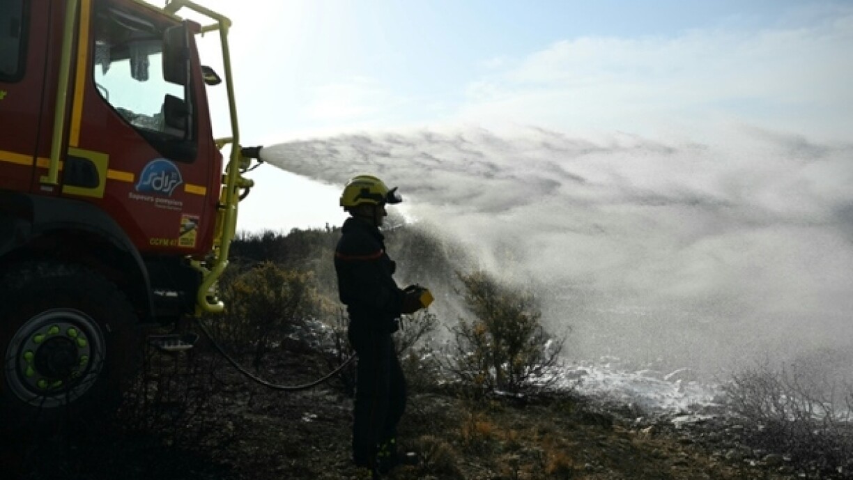 Des pompiers éteignent des cendres chaudes à côté d'Albas, dans le massif des Corbières, le 9 août 2025