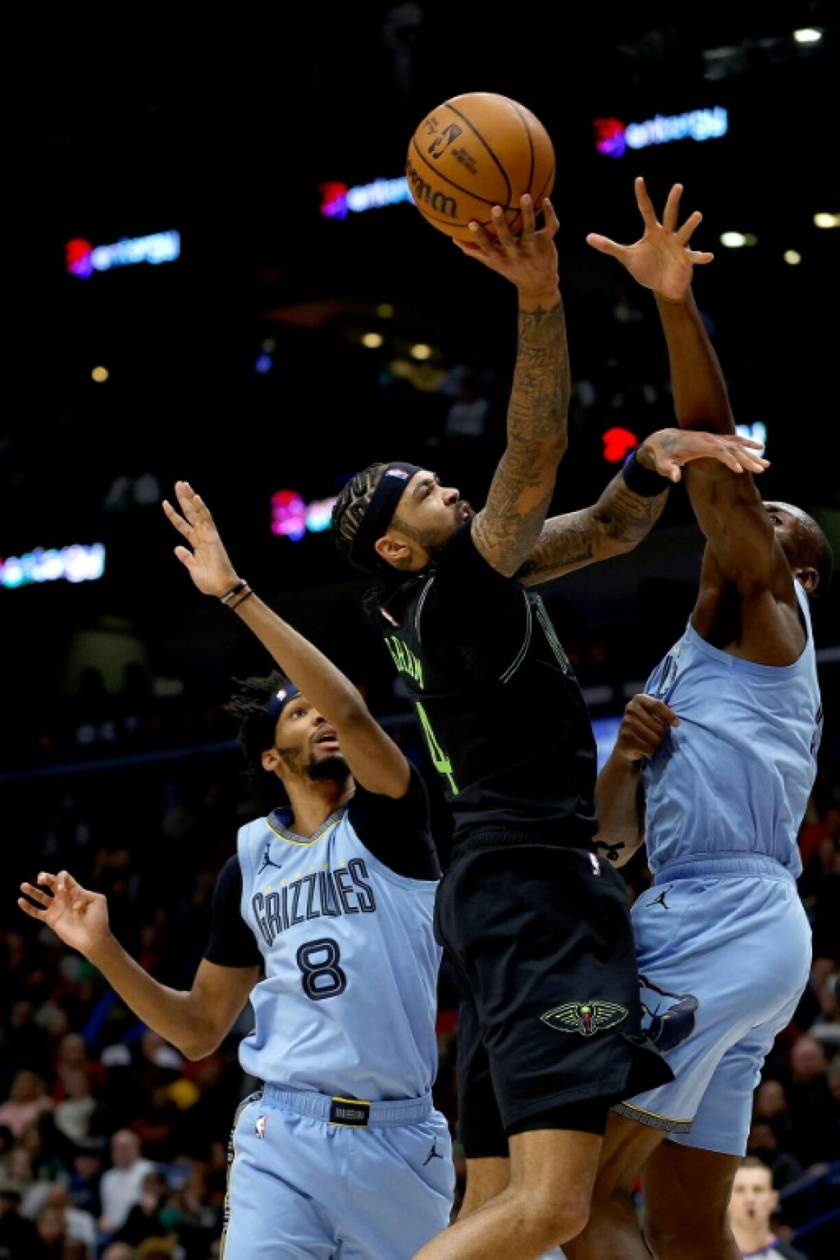 Brandon Ingram des New Orleans, empêtré dans la défense des Memphis Grizzlies, tente d'aller au panier, le 26 décembre 2023 en NBA à la Nouvelle-Orléans