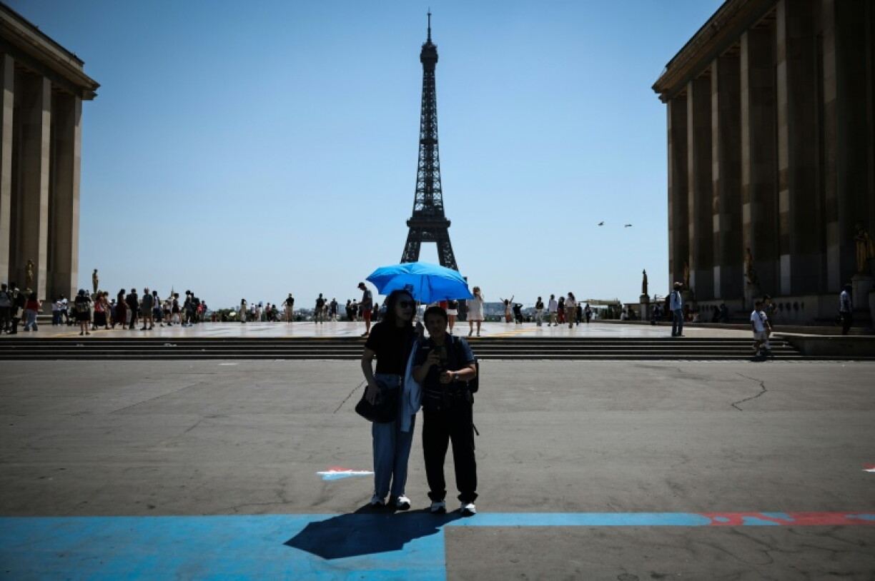 Des touristes se protègen du soleil au Trocadéro à Paris, le 18 juin 2026