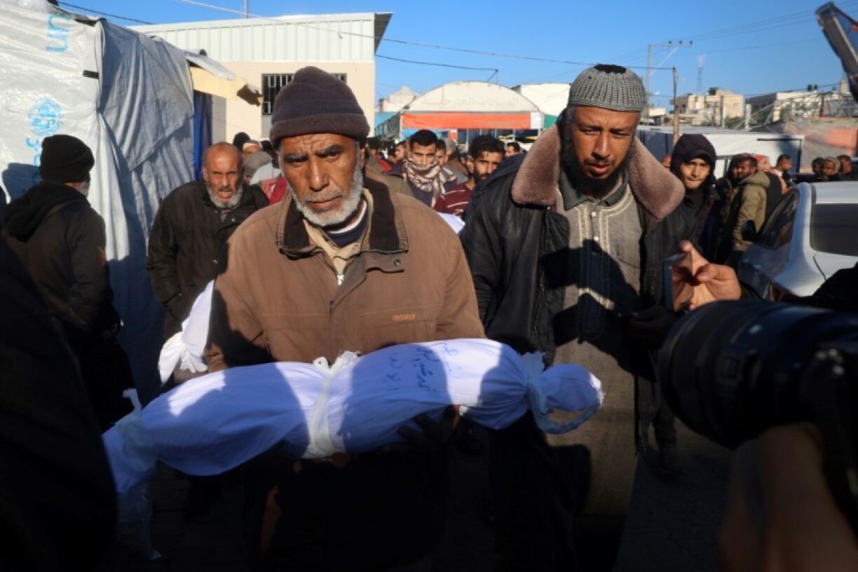 A man outside a hospital in Deir el-Balah, central Gaza, carries the body of a Palestinian child killed in an Israeli strike