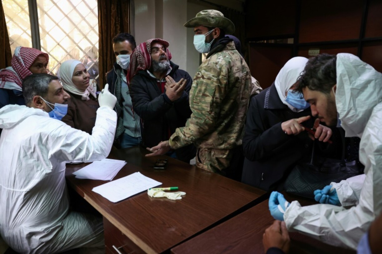 Syrians searching for missing relatives talk with the new authorities at a Damascus morgue.
