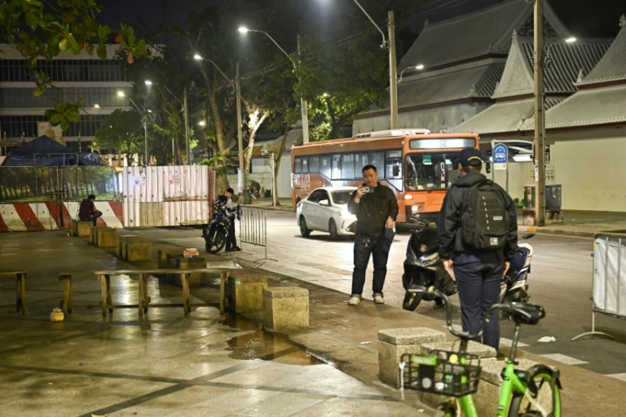 Central Investigation Bureau (CIB) members stand near the spot where former Cambodian MP was reportedly shot in Bangkok