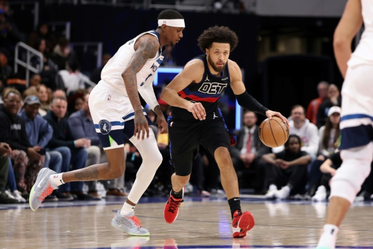 Cade Cunningham of the Detroit Pistons drives around Jaden McDaniels in an NBA victory over the Minnesota Timberwolves