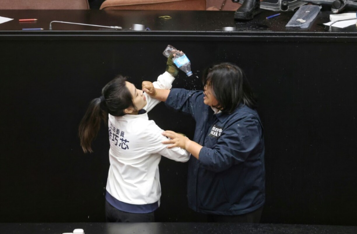 Taiwan opposition party Kuomintang (KMT) lawmaker Hsu Chiao-hsin (L) splashes water on Democratic Progressive Party (DPP) lawmaker Wang Mei-hui