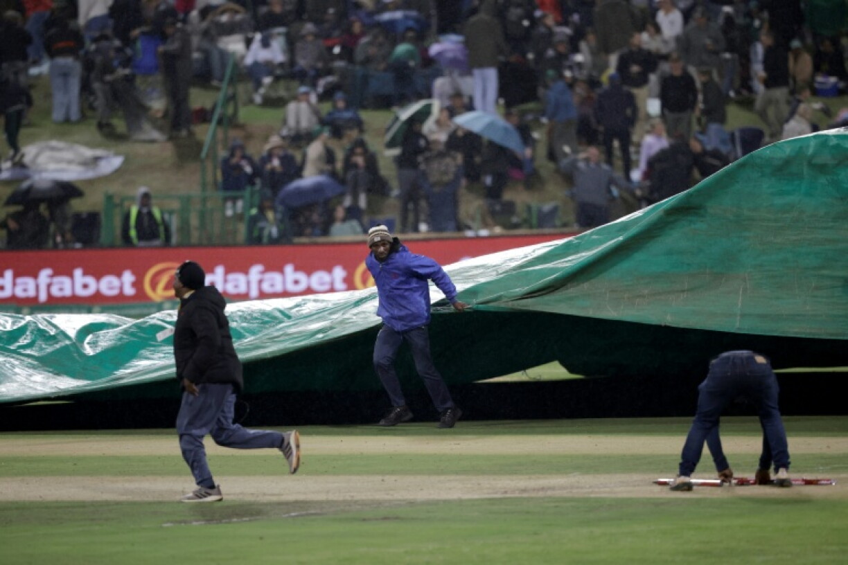 Ground staff bring the covers on during the third one-day international (ODI) cricket match between South Africa and Australia at Senwes Park in Potchefstroom