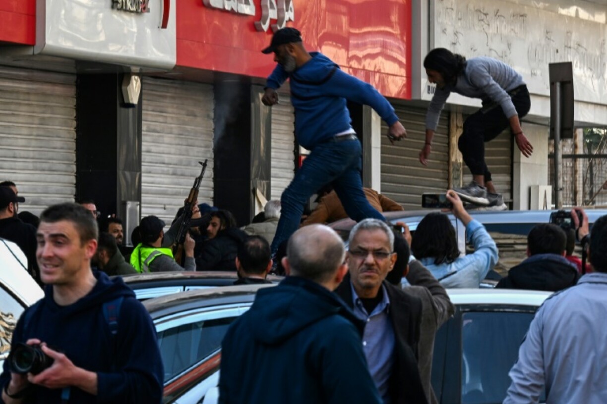 A gunman fires shots in the air to disperse clashing protesters in Syria's capital Damascus, after reported mass killings of the minority Alawite community