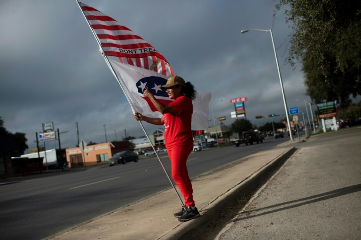 Un militante républicaine brandit un drapeau à l'extérieur d'un bureau de vote d'Uvalde, au Texas, le 8 novembre 2022