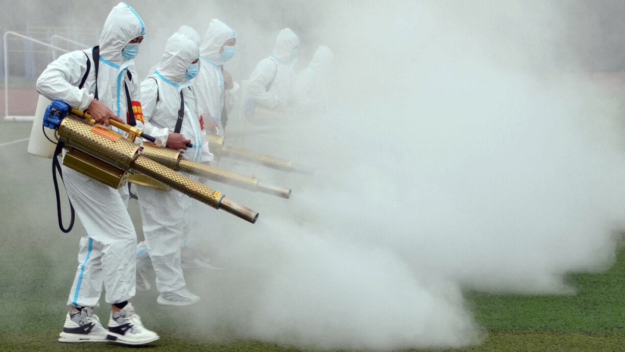Staff members spray disinfectant at a school ahead of the new semester in Bozhou in China's eastern Anhui province on August 23, 2021.