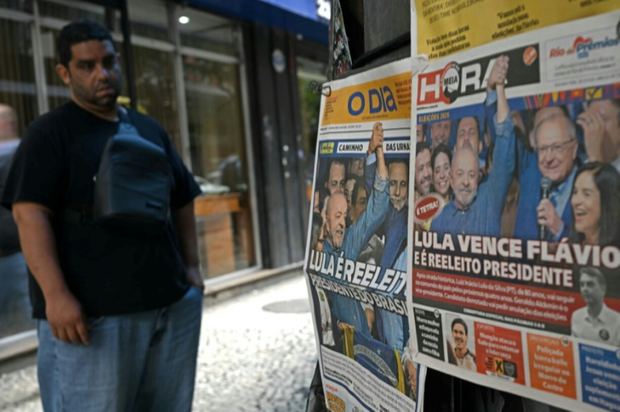 A man looks at newspapers whose frontpage display the victory of Brazil's President and re-election candidate Luiz Inacio Lula da Silva