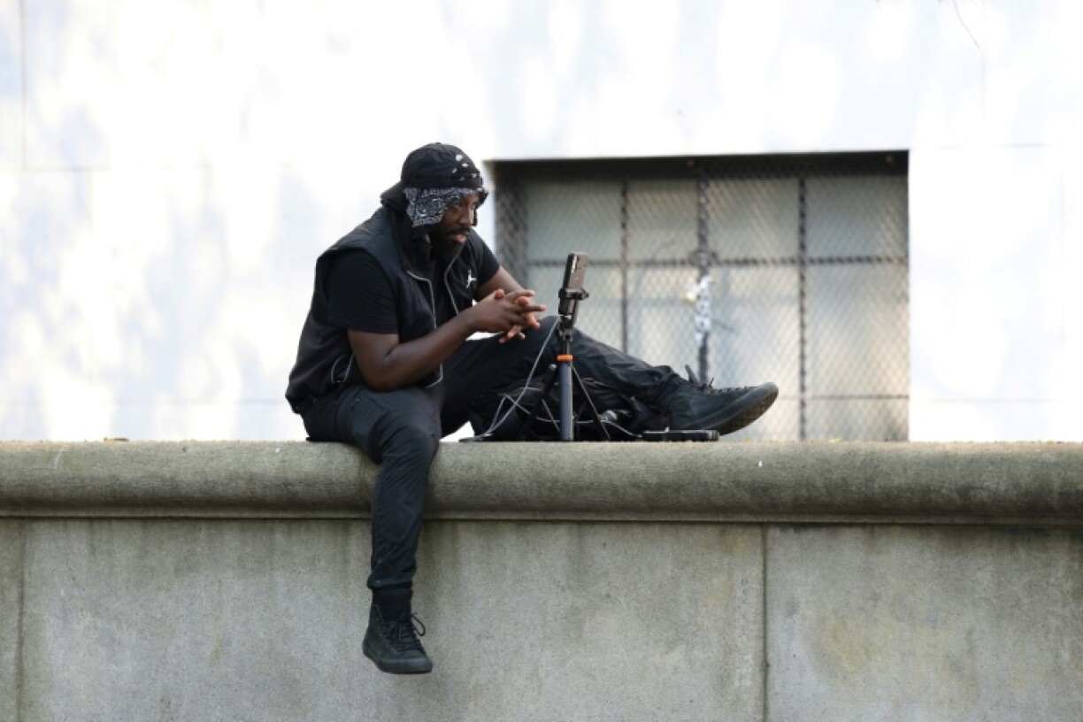 A man livestreams outside the Manhattan federal courthouse, where Sean
