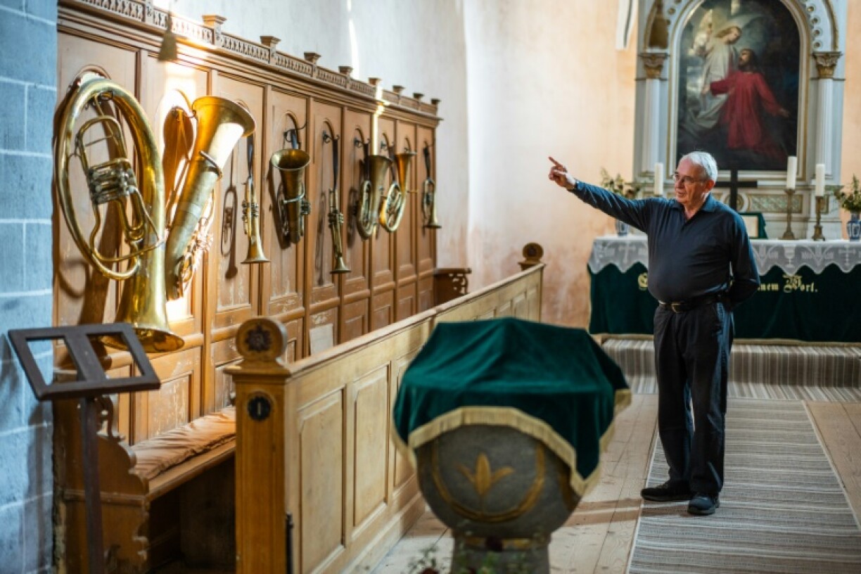 Former history teacher Michael Lisske shows off the old brass instruments inside the fortified church of Cincsor