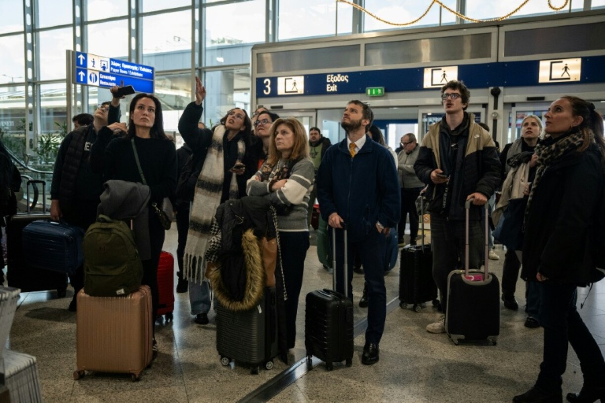Des voyageurs attendent à l'aéroport d'Athènes-Spata après des retards et des reports de vols dans le pays dus à un "problème technique", le 4 janvier 2026