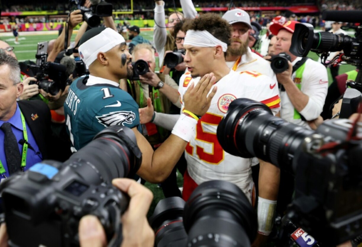 Quarterbacks Jalen Hurts of the Philadelphia Eagles and Patrick Mahomes of the Kansas City Chiefs embrace after Super Bowl 59, which drew a US television record audience of 127.7 million people according to Nielsen