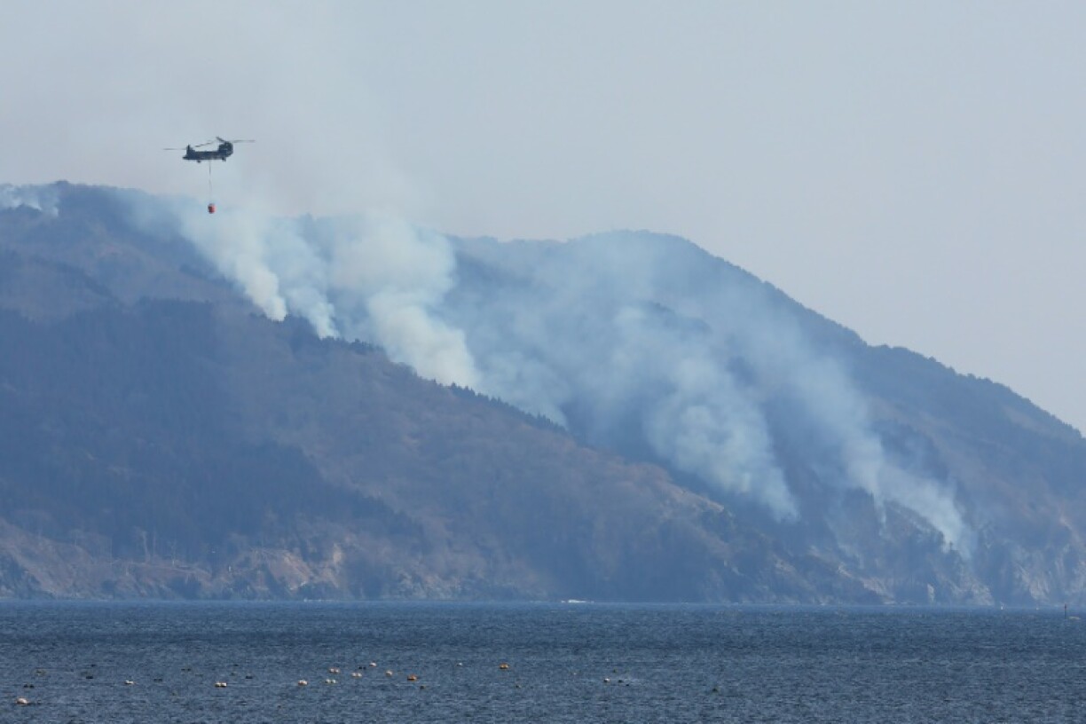 A helicopter is pictured above the wildfire near Ofunato