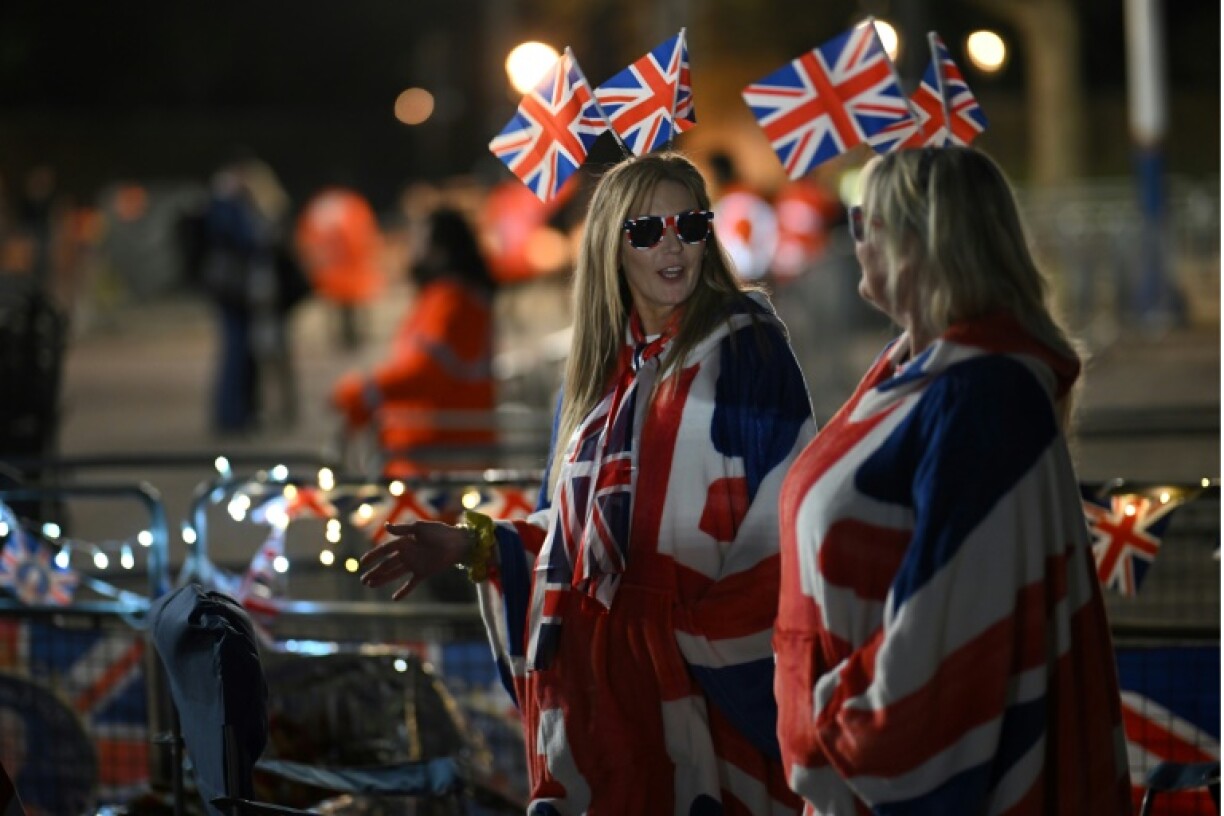 Des spectateurs attendent sur le parcours du cortège du couronnement, le 4 mai 2023 sur The Mall à Londres