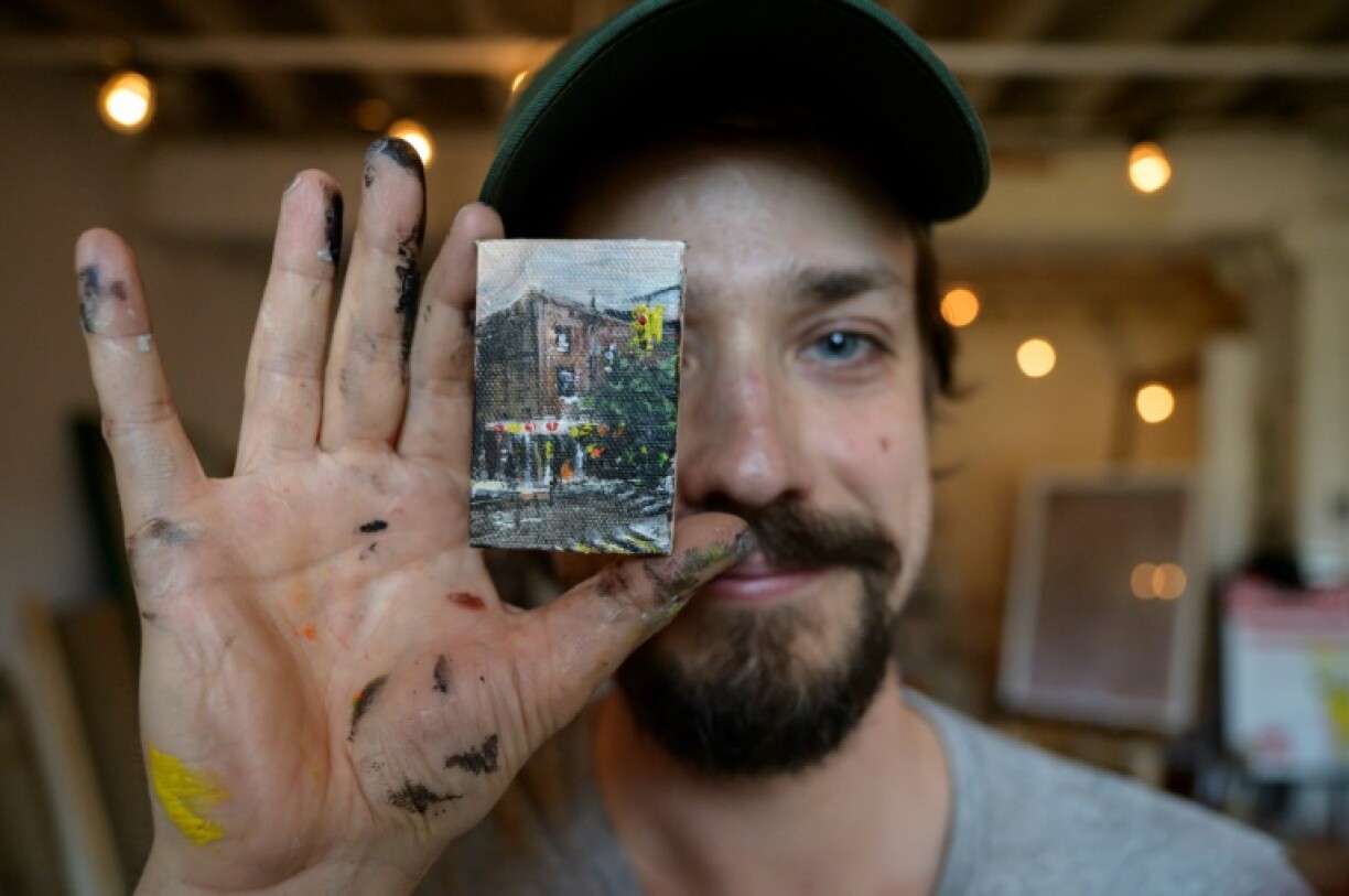 Steve Wasterval montre l'un de ses tableaux miniatures, dans le quartier de Greenpoint, le 25 mai 2021 à New York