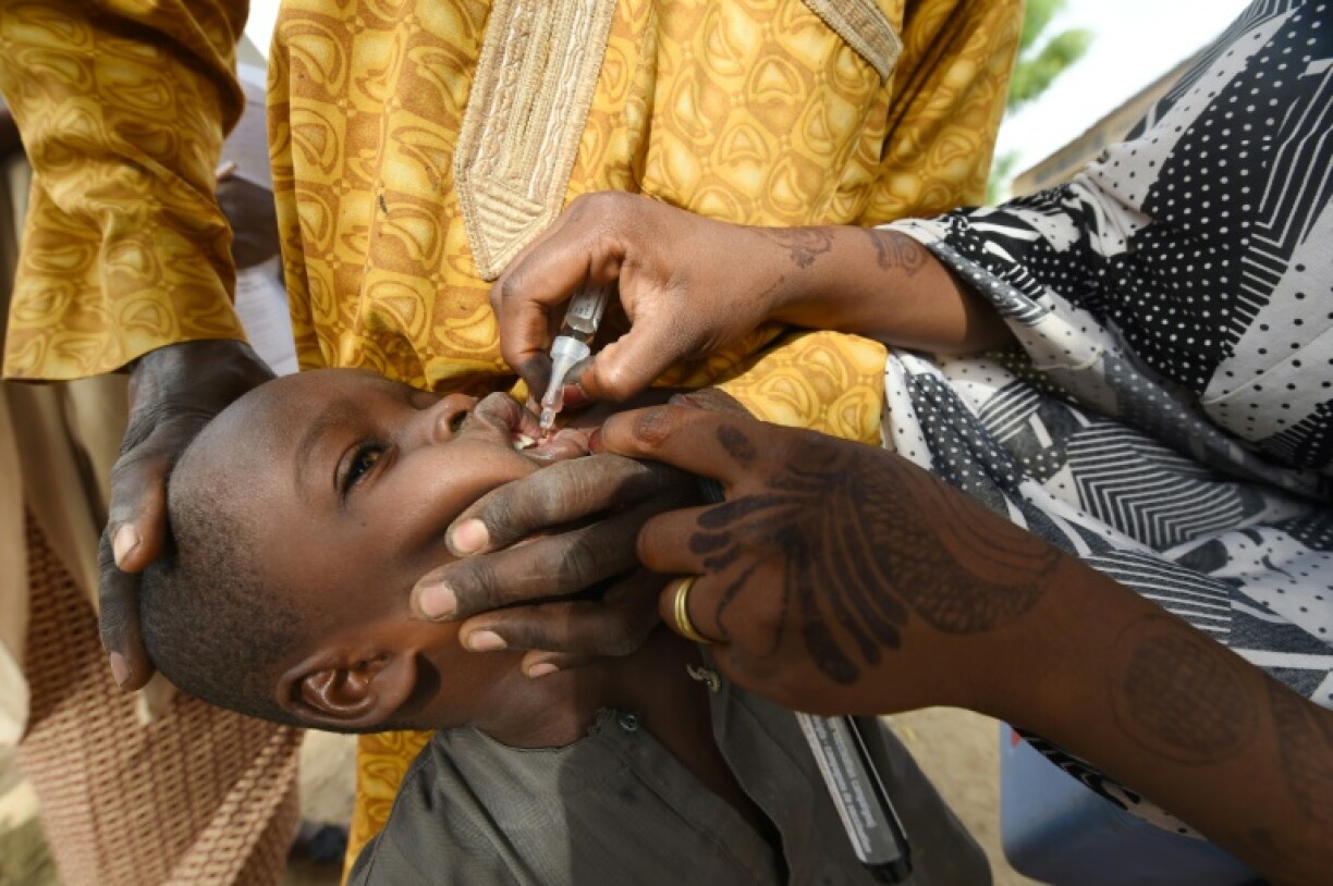 Health worker tries to immunise a child during a vaccination campaign against polio at Hotoro-Kudu, Nassarawa district of Kano in northwest Nigeria