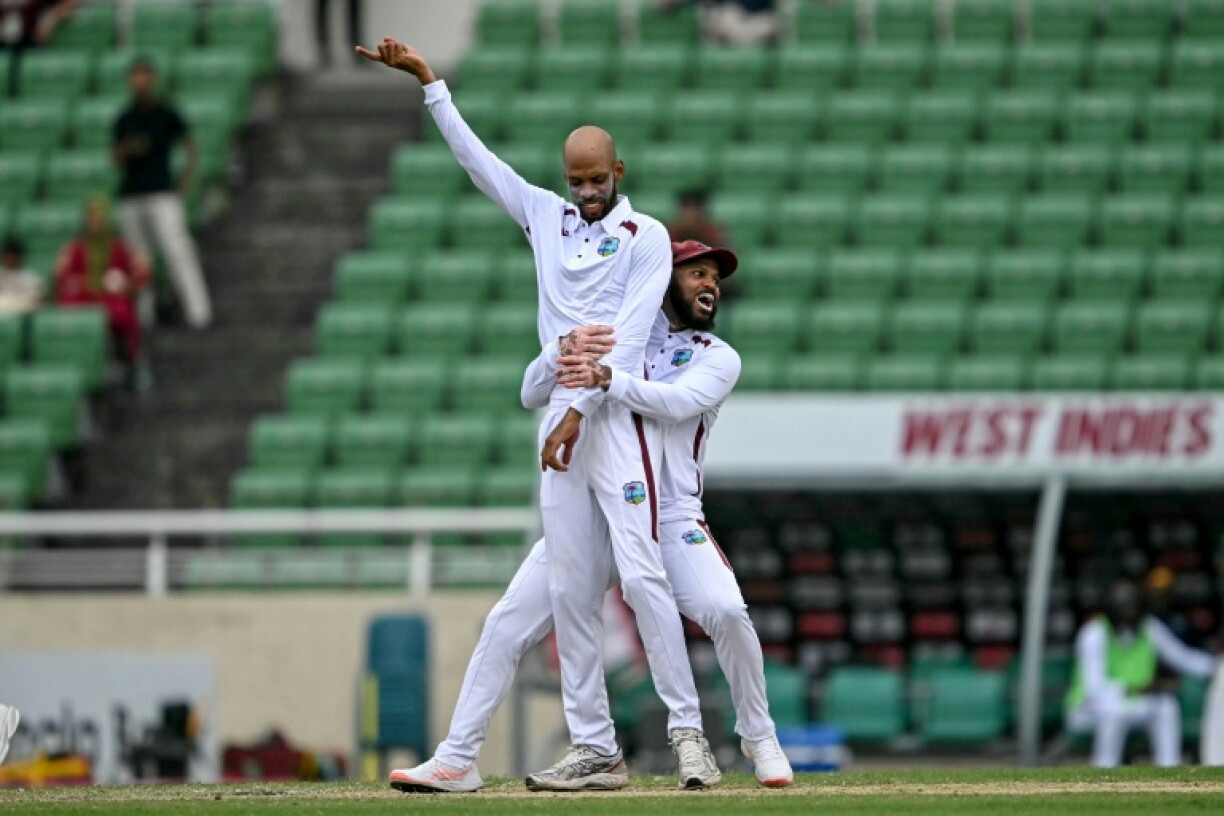 West Indies' captain Roston Chase (L) celebrates with teammate John Campbell after taking the wicket of Bangladesh's Towhid Hridoy during the third day of the first test cricket match between Bangladesh and West Indies at the Sher-e-Bangla National Stadium in Mirpur on October 30, 2026.