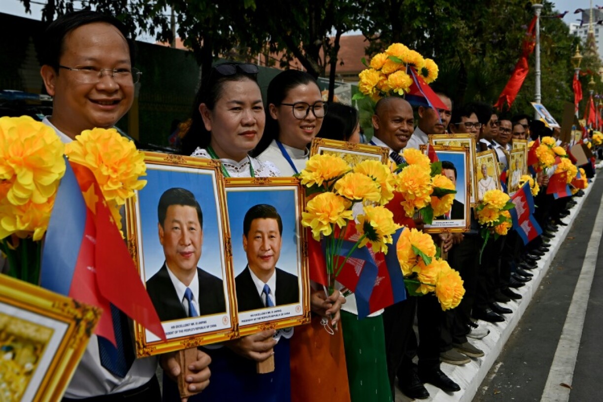 Cambodians held portraits of Xi Jinping to welcome the Chinese president to Phnom Penh