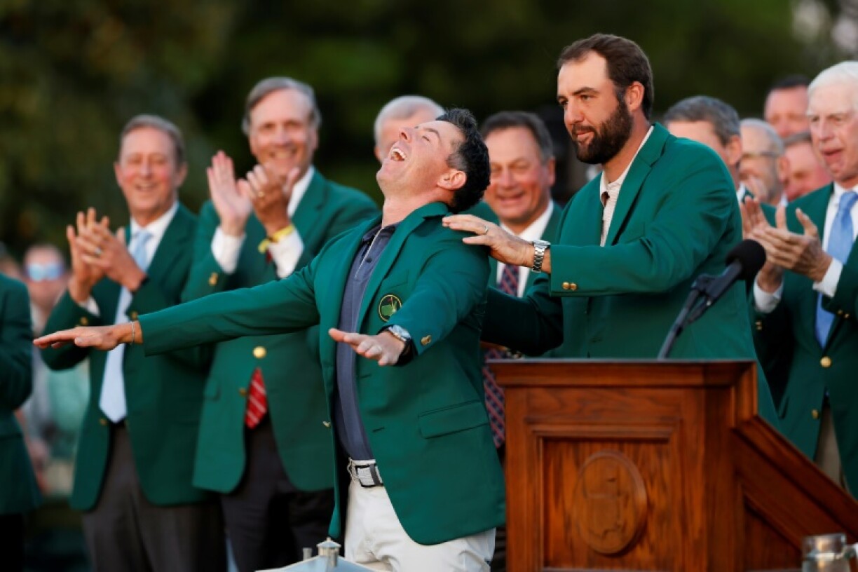 Northern Ireland's Rory McIlroy reacts as he is awarded the green jacket by 2024 champion Scottie Scheffler after a playoff triumph over Justin Rose at Augusta National