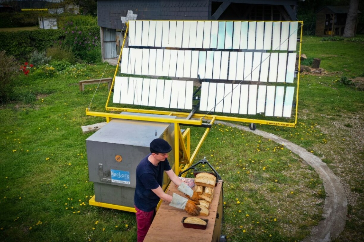 Le boulanger-torréfacteur Arnaud Crétot sort son pain qui a cuit dans un four solaire, le 2 mai 2023 à Montville, près de Rouen, en Normandie