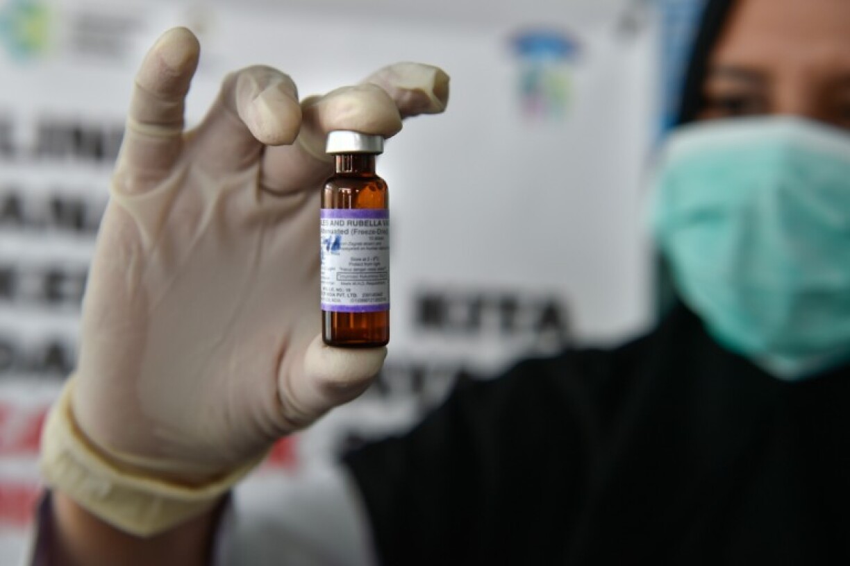A medical worker holds a measles-rubella (MR) vaccine at a health station in Banda Aceh in Aceh province on September 19, 2018.