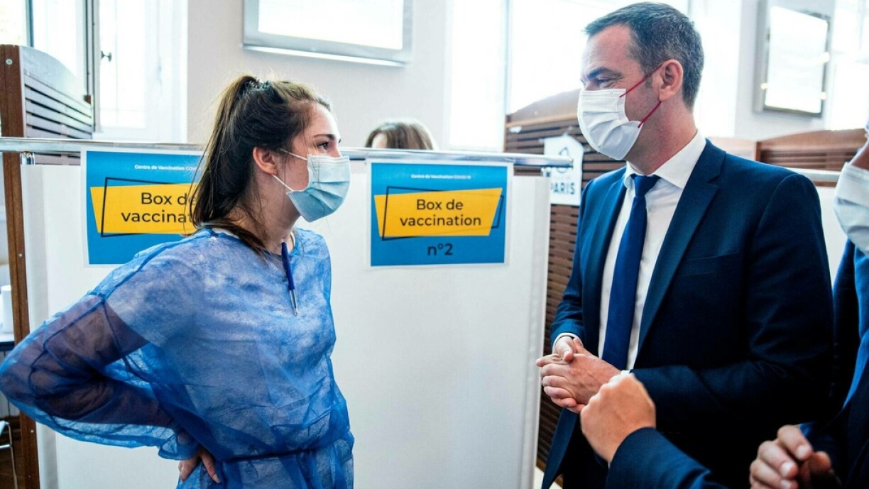 French Health Minister Olivier Veran (R) speaks with a nurse as he visits a Covid-19 vaccination centre in Paris, on June 15, 2021, on the day France starts vaccinating teenagers from age 12 with the Pfizer BioNTech vaccine.