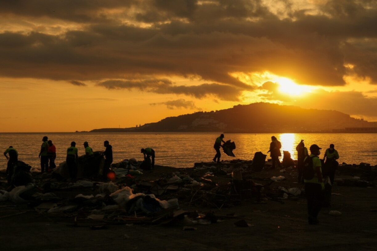 Workers clear debris after Spanish police evicted migrants from a makeshift camp in Ceuta at dawn