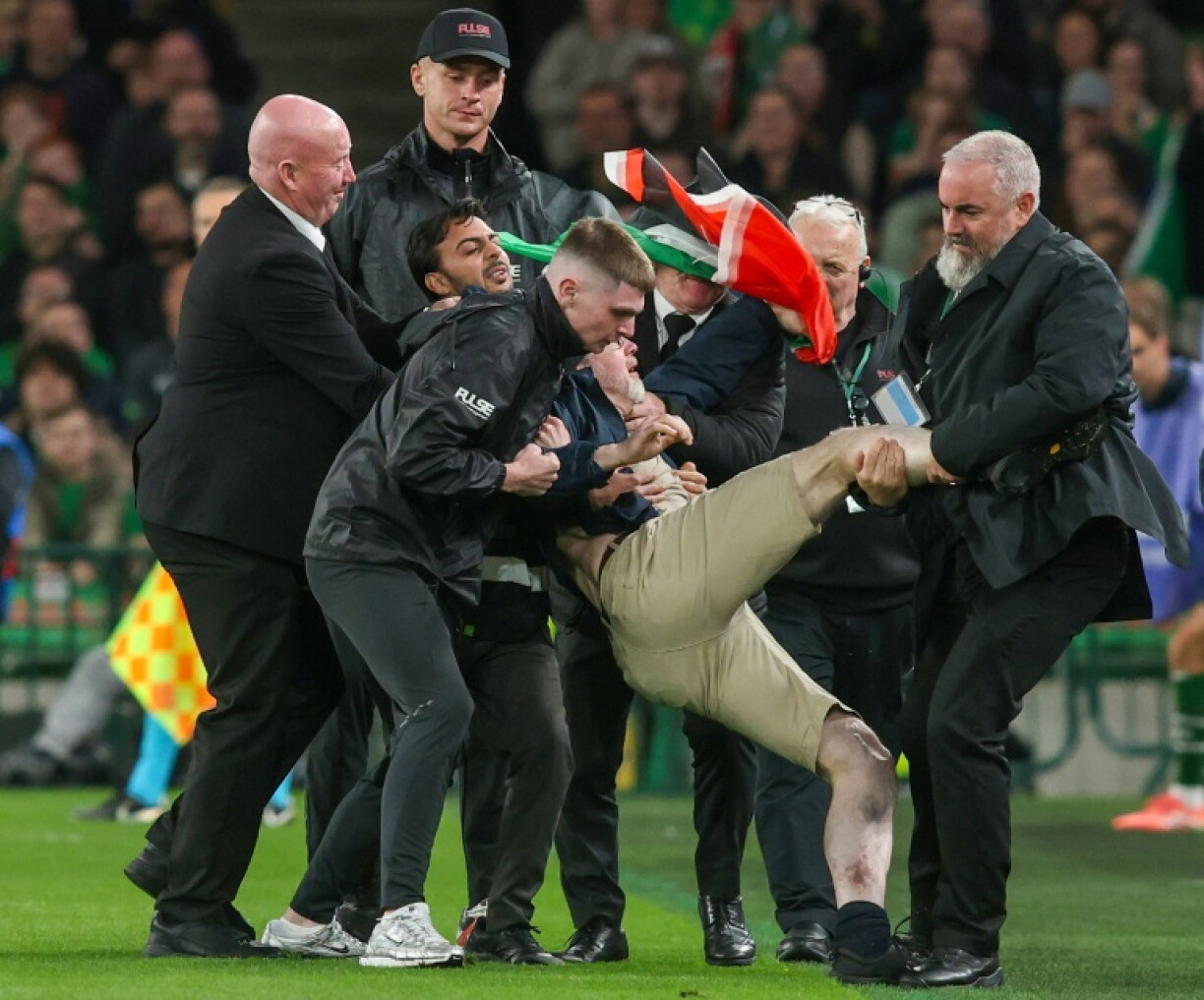 A pitch invader is carried away after interrupting Ireland's game against Austria