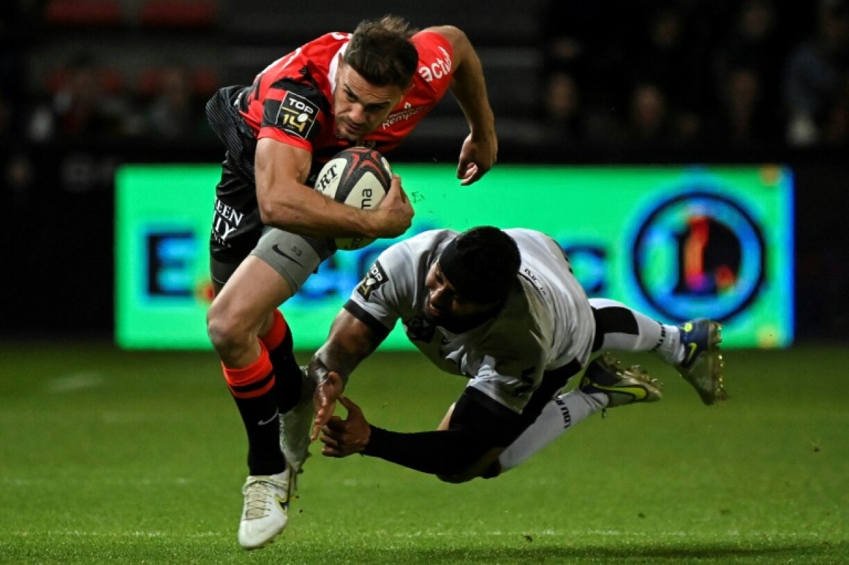 L'arrière de Toulouse Melvyn Jaminet échappe au plaquage d'un Lyonnais en Top 14 le 16 avril 2023 au stade Ernest-Wallon à Toulouse