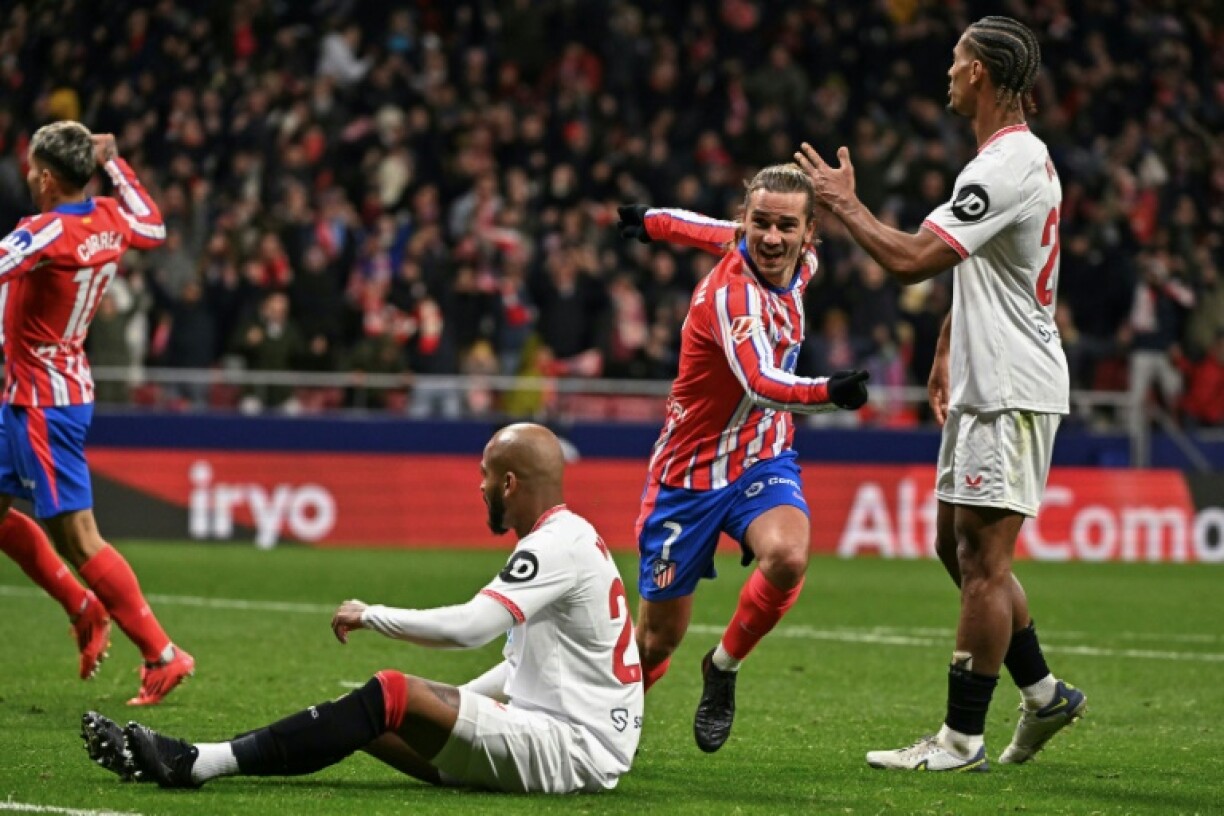 Atletico Madrid's French forward Antoine Griezmann (2R) celebrates scoring their fourth goal in the wild win over Sevilla