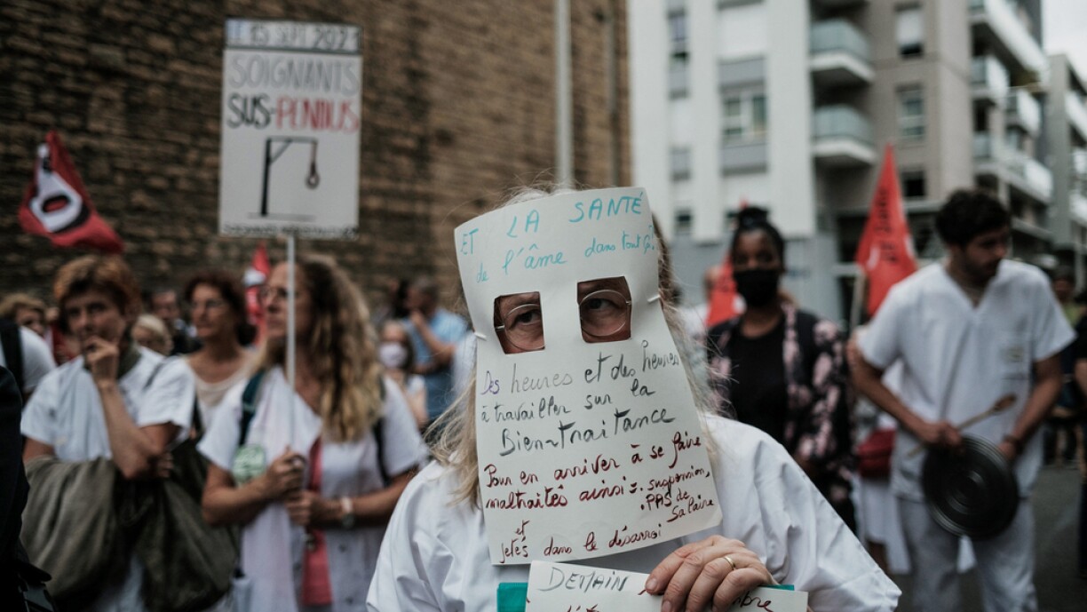 A Nursing staff member wears a handmade mask as he demonstrates in front of The A.R.S (regional health agency)in Lyon, south-eastern France on September 14, 2021, against mandatory health passport 'pass sanitaire' obligation for hospital workers which the government is attempting to enforce to fight the coronavirus(Covid-19).