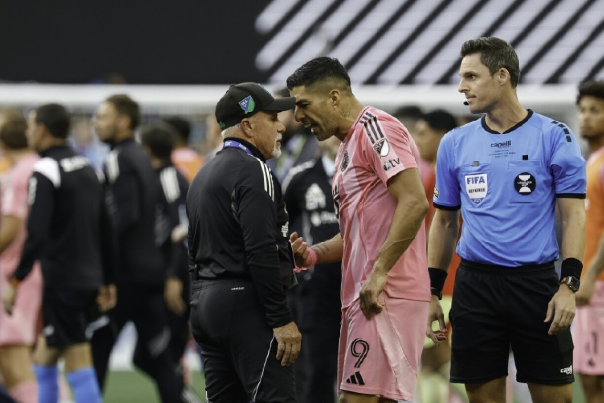 Inter Miami's Luis Suarez, center, speaks with head of security Gene Ramirez, left, of the Seattle Sounders after the Leagues Cup Final match won by Seattle over Miami and a melee that brought Suarez a six-match Leagues Cup ban