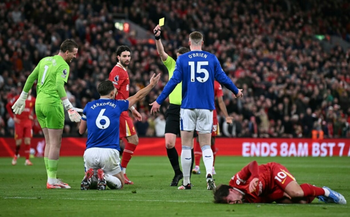 James Tarkowski (2nd left) is shown a yellow card for his foul on Alexis Mac Allister (right)
