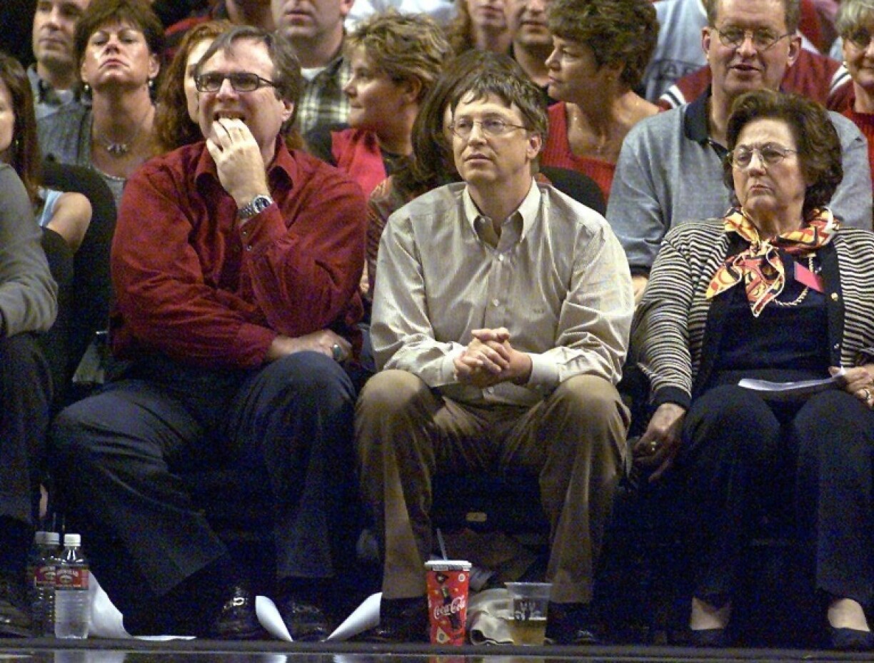 Bill Gates (C) and Paul Allen (L), pictured here at a Portland Trailblazers basketball game in May 2000, founded Microsoft in 1975 with a mission to put computers in every home and office