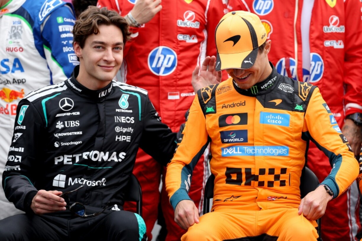 Le pilote Mercedes George Russell (à gauche) avec celui de McLaren Lando Norris avant le GP d'Australie dans le paddock du circuit Albert Park à Melbourne, le 8 mars 2026