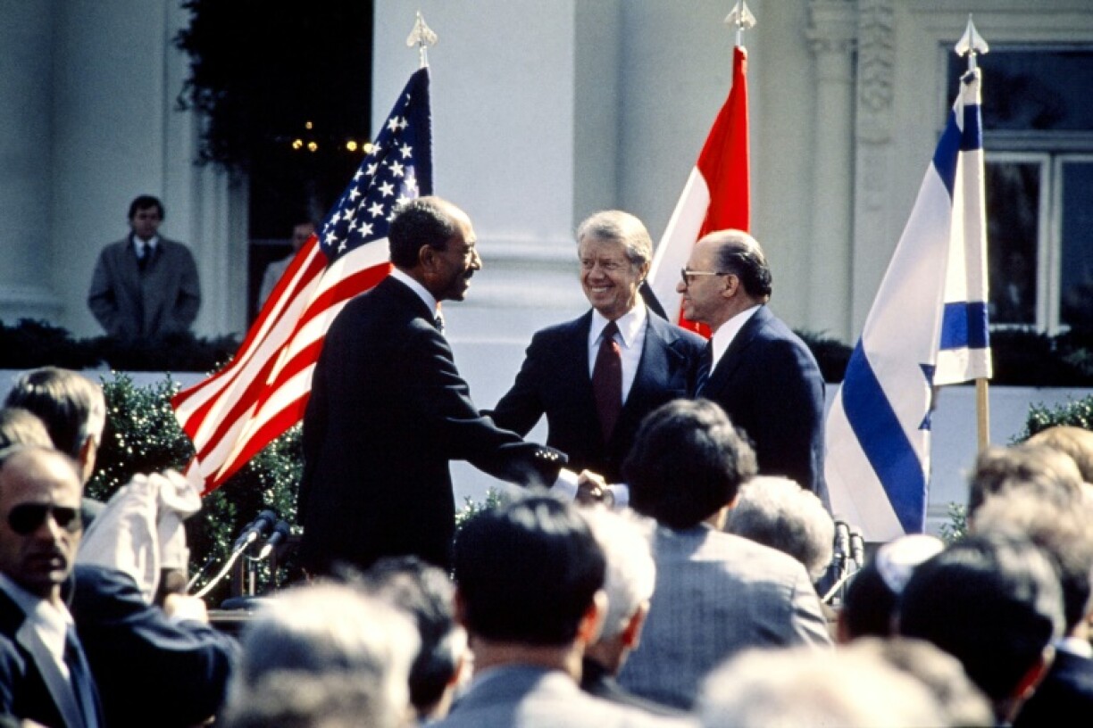US President Jimmy Carter (C) congratulates Egyptian President Anwar al-Sadat (L) and Israeli Prime Minister Menachem Begin (R) on March 26, 1979 on the north lawn of the White House after the signing of a historic peace treaty
