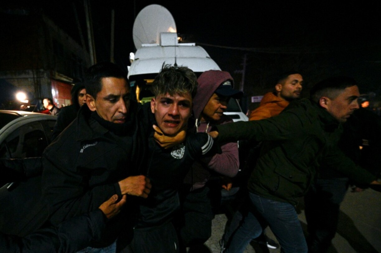 People restrain a man during a fight between supporters and opponents of Argentina's President Javier Milei