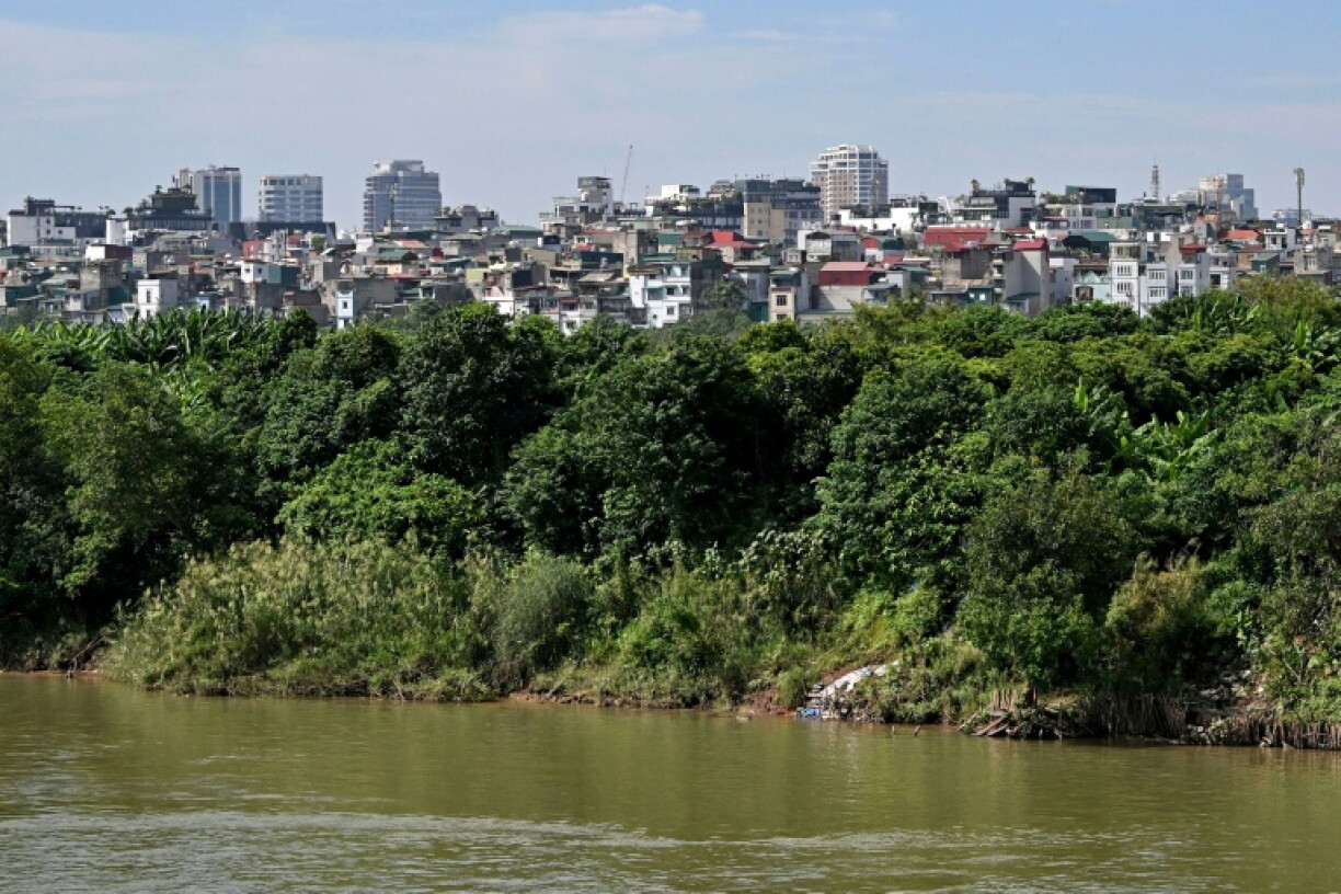 The Red River flows against the backdrop of a residential area in Hanoi