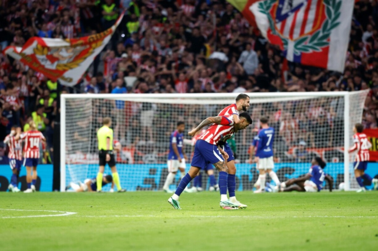 Les défenseurs mancuniens au sol, en arrière-plan, tandis que Cristian Romero et David Hancko fêtent le deuxième but de l'Atlético Madrid contre Manchester United, en Ligue des champions, le 13 octobre 2026 au Metropolitano
