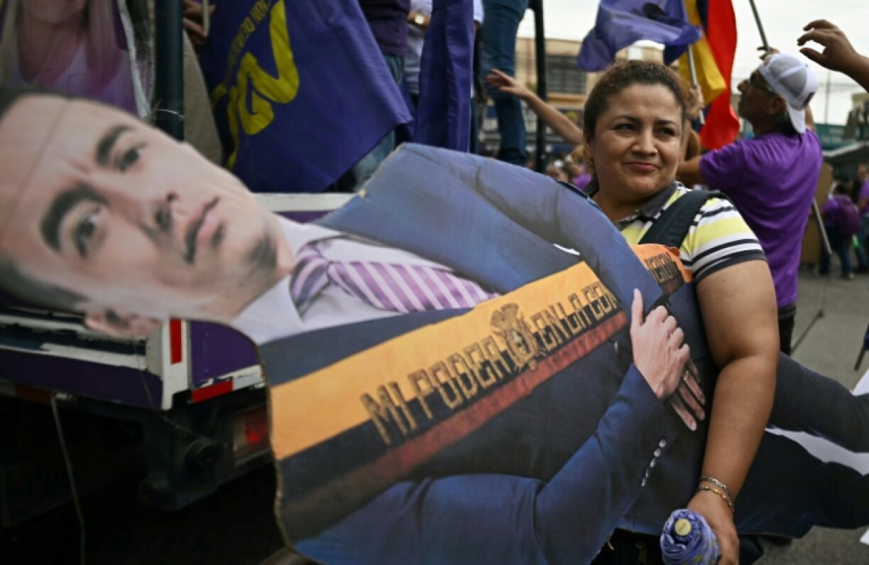 A supporter carries a human size cardboard of Ecuadoran President Daniel Noboa