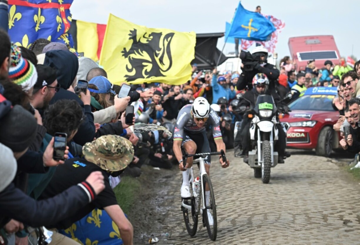 Liquid is thrown as Mathieu van der Poel battles past on the cobbles of Paris-Roubaix