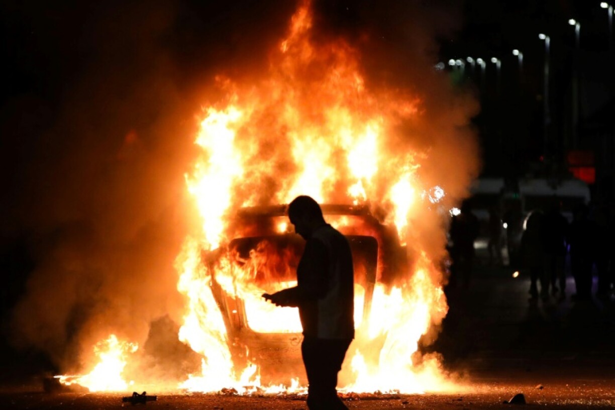 Une voiture en feu lors d'émeutes visant des immigrés à Ballymena, le 10 juin 2025 en Irlande du Nord
