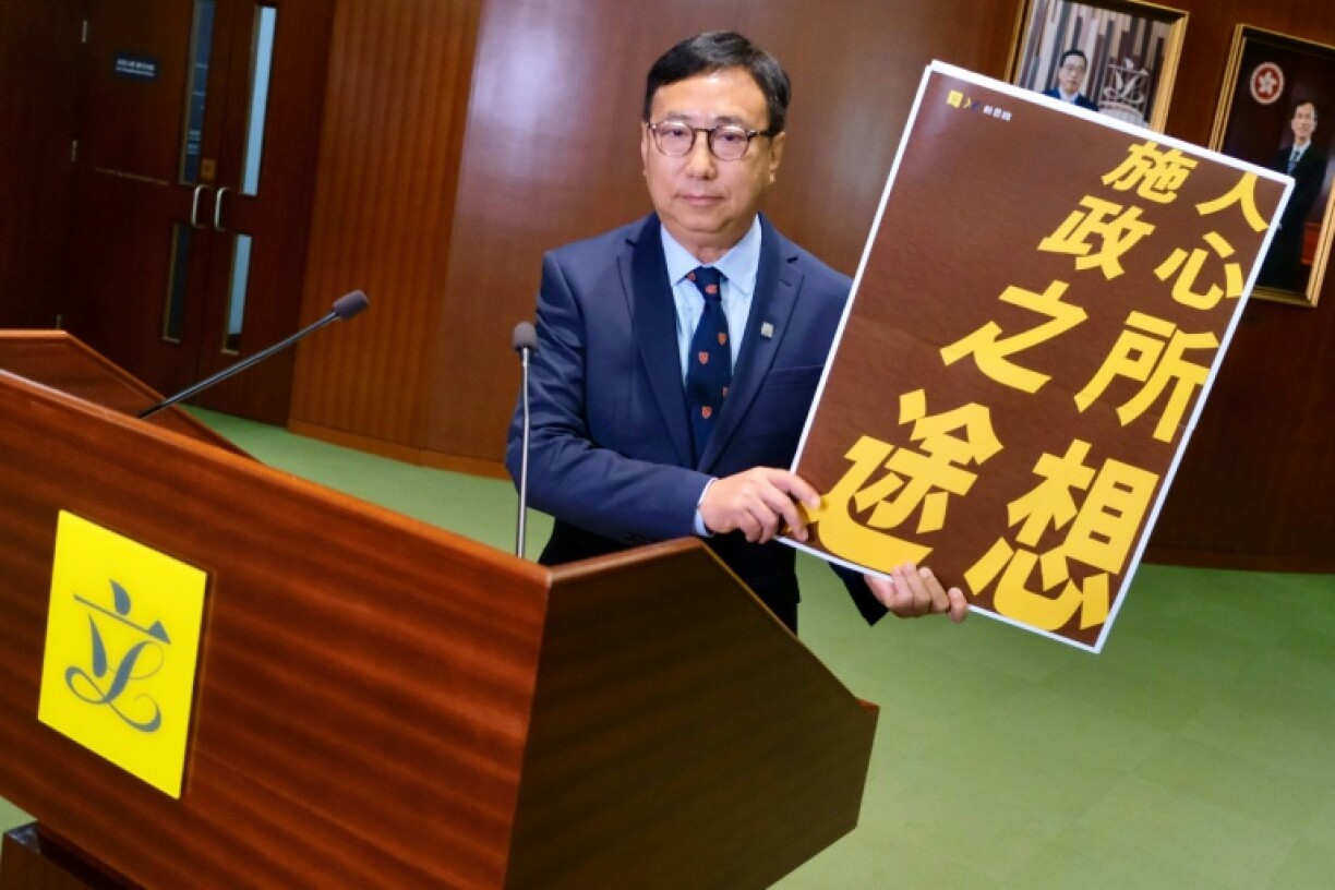 Lawmaker Tik Chi-yuen holds a sign reading
