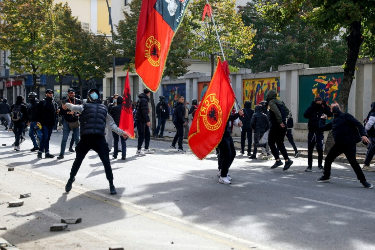 Protesters throw objects at riot police during an anti-government demonstration in central Tirana on October 15, 2026, as protests continued for a third consecutive day over university conditions and demands for the resignation of Albanian Prime Minister Edi Rama. The latest rally follows two nights of violence in the capital, during which protesters and riot police clashed, police used water cannons and tear gas, and demonstrators damaged government offices and shops and set fire to several buildings.